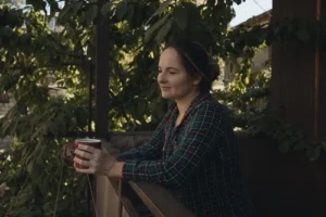 Woman at railing holding a mug