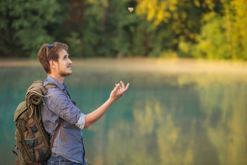 Backpacker tossing rock
