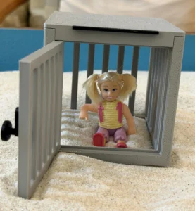 Miniature in cage with door open