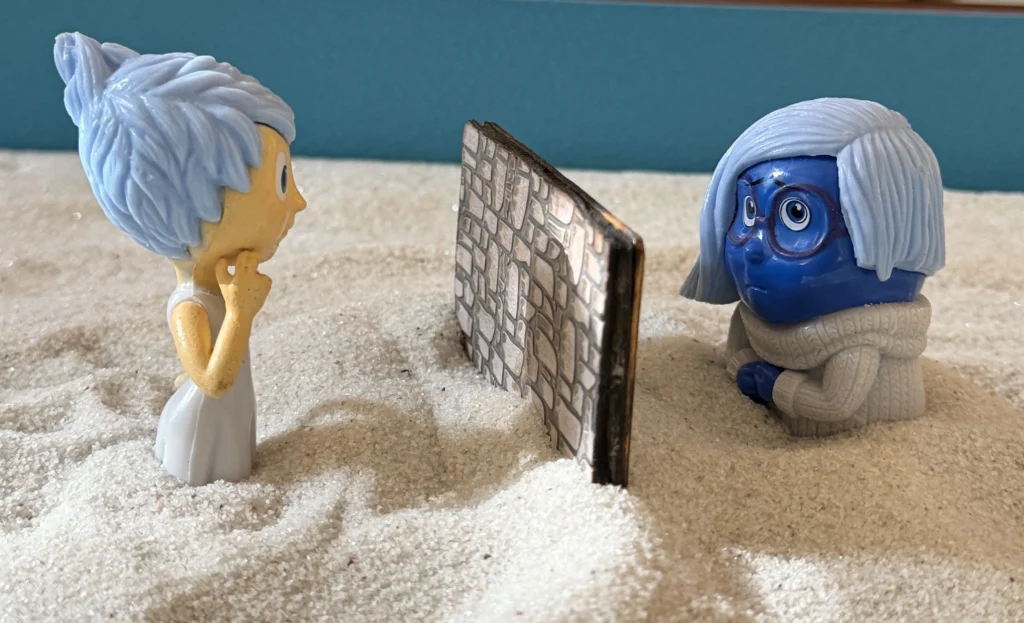 Joy and Sadness separated by a wall